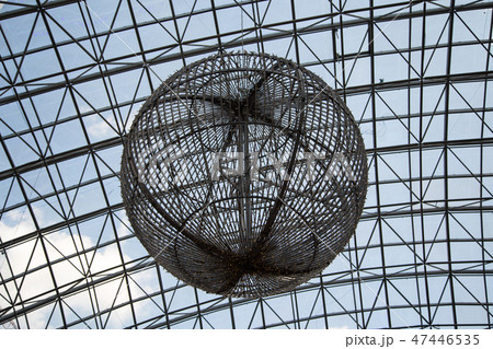A large metal ball against the glass roof 47446535