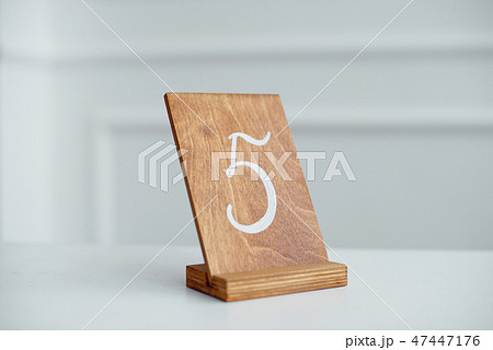 Vintage rectangular shaped wooden number buttons on a white wooden table. 47447176