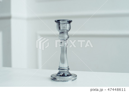 Glass candlesticks transparent blue glass on a wooden white table in a white room. 47448611