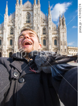Italy, excursion and travel concept - funny guy taking selfie with pigeons in front of cathedral Italy, excursion and travel concept - funny guy taking selfie with pigeons in front of cathedral 47449274