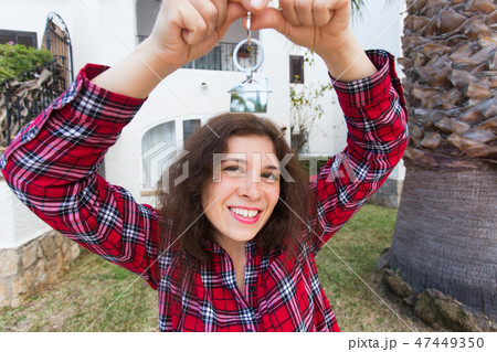New home, house, property and tenant - Young funny woman holding key in front of her new home after 47449350