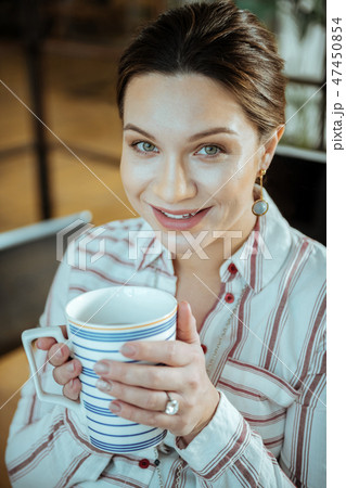 Pleasant woman enjoying her break from work drinking tea Pleasant woman enjoying her break from work drinking tea 47450854