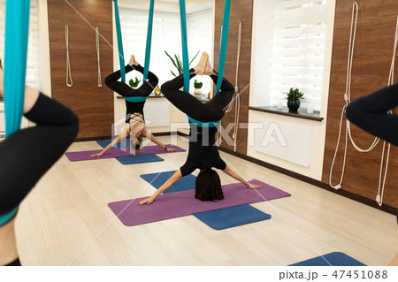 a group of women hang upside down in a hammock 47451088