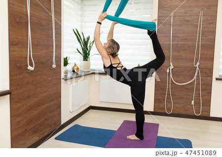 Woman doing fly yoga stretching standing on one  47451089