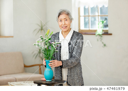 花瓶に花を指すシニア女性の写真素材