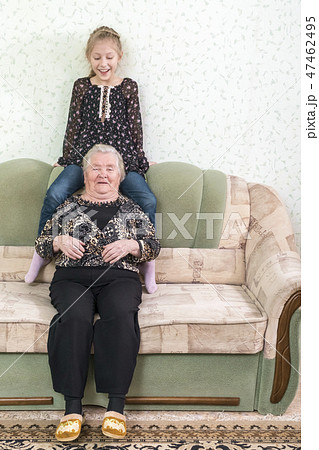 Granddaughter with great-grandmother on the couch Granddaughter with great-grandmother on the couch 47462495