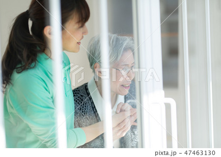外を眺めるシニア女性と介護士 外を眺めるシニア女性と介護士 47463130