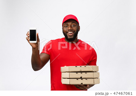 Delivery Concept: Handsome african pizza delivery man talking to mobile with shocking facial 47467061