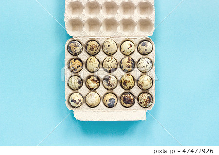 Quail eggs in cardboard box on blue background Quail eggs in cardboard box on blue background 47472926