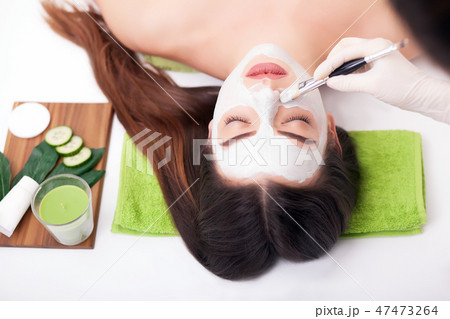 Hardware cosmetology. Closeup picture of lovely young woman with cream mask in a beauty parlour. 47473264