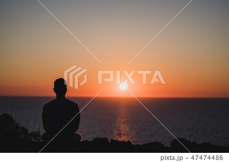 Young man looking to the sunset over sea. Enjoying and relaxing concept, full of unforgettable 47474486