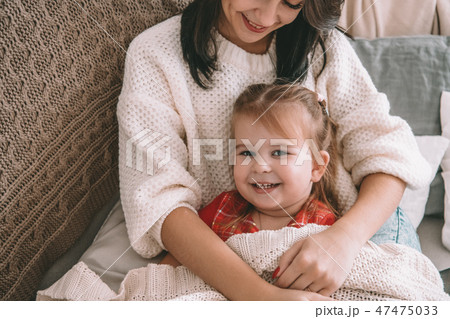 The happy daughter and a mother laughing on the bed The happy daughter and a mother laughing on the bed 47475033