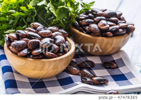 Uncooked beans in wooden bowles on kitchen table. Uncooked beans in wooden bowles on kitchen table. 47476365