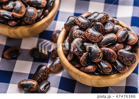 Uncooked beans in wooden bowles on kitchen table. Uncooked beans in wooden bowles on kitchen table. 47476366