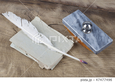Quill pen and glass inkwell with old letters Quill pen and glass inkwell with old letters 47477496