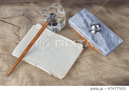 Quill pen and glass inkwell with old letters Quill pen and glass inkwell with old letters 47477503