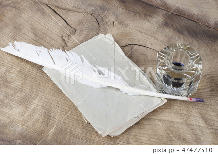 Quill pen and glass inkwell with old letters 47477510