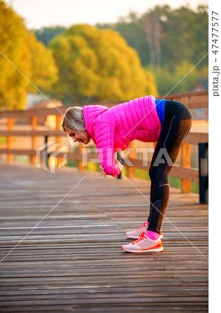 Image of young girl stretching in summer park 47477577