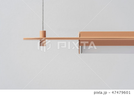 Orange metal lamp hanging on gray wall background in studio 47479601