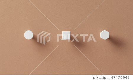 Metal white hangers in forms of circle and square and hexagon on orange wall in studio Metal white hangers in forms of circle and square and hexagon on orange wall in studio 47479945