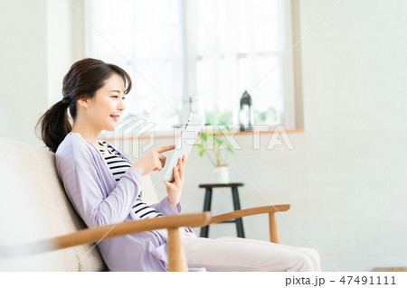 タブレット端末を操作する若い女性  インターネット  女の子  ライフスタイル 女性ポートレート 47491111
