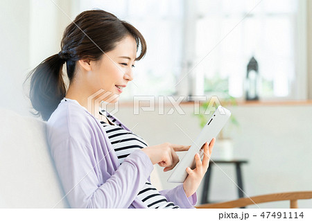 タブレット端末を操作する若い女性  インターネット  女の子  ライフスタイル 女性ポートレート 47491114