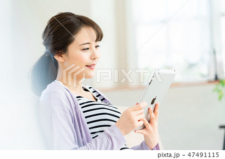 タブレット端末を操作する若い女性  インターネット  女の子  ライフスタイル 女性ポートレート 47491115