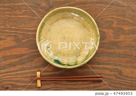 茶色いテーブルに置かれた土製の皿と箸 茶色いテーブルに置かれた土製の皿と箸 47493953