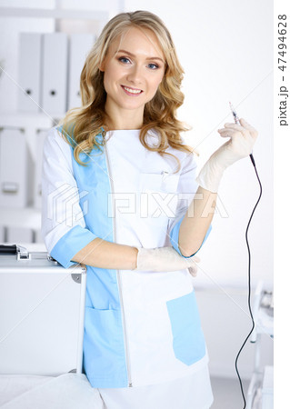 Portrait of professional female beautician standing straight in beauty salon. Makeup artist ready to Portrait of professional female beautician standing straight in beauty salon. Makeup artist ready to 47494628