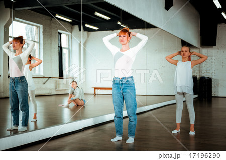 Red-haired ballet teacher and her student dancing near the mirror Red-haired ballet teacher and her student dancing near the mirror 47496290