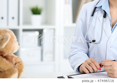 Unknown female doctor working at the desk with clipboard in hospital and filling up medical history Unknown female doctor working at the desk with clipboard in hospital and filling up medical history 47496516