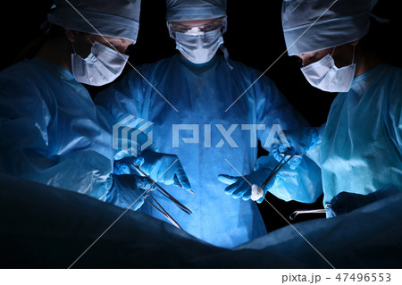 Group of surgeons in masks performing operation. Medicine, surgery and emergency help concepts Group of surgeons in masks performing operation. Medicine, surgery and emergency help concepts 47496553