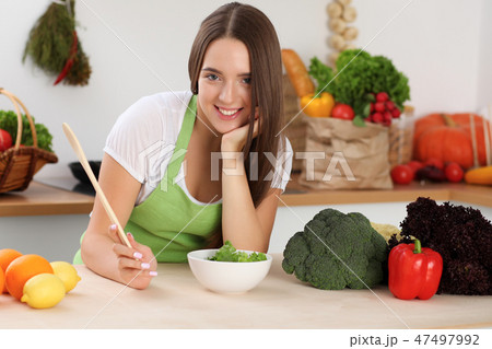 Young woman cooking in kitchen. Householding, tasty food and digital technology in lifestyle 47497992