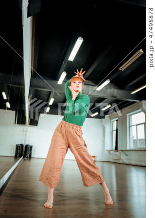 Red-haired professional dance teacher dancing in the studio Red-haired professional dance teacher dancing in the studio 47498878