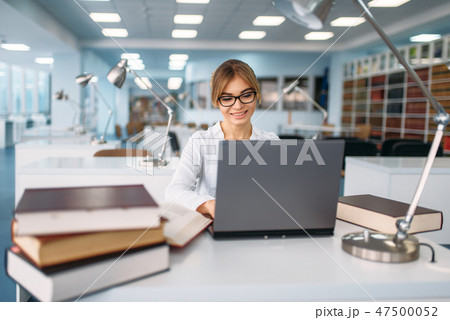 Female student studying at the laptop in library 47500052