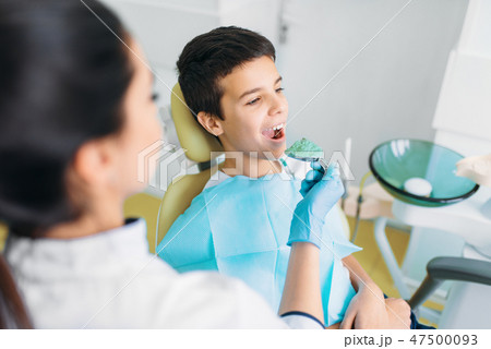 Female dentist with paste for teeth impression Female dentist with paste for teeth impression 47500093
