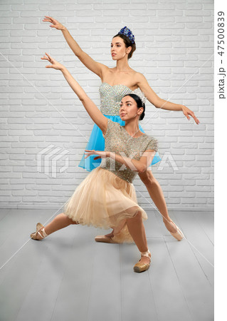 Ballerinas in beige and blue dresses looking above in studio 47500839