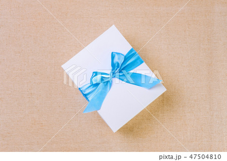 Top view of white gift box tied by blue ribbon 47504810
