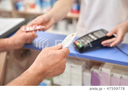 Man holding credit card after payment using terminal. 47509778