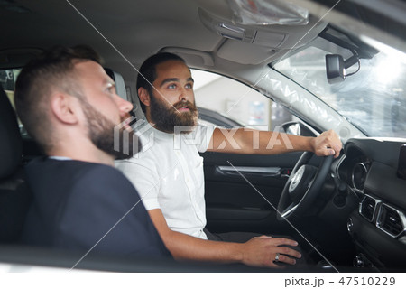 Man sitting in driver's seat, testing car with manager. Man sitting in driver's seat, testing car with manager. 47510229