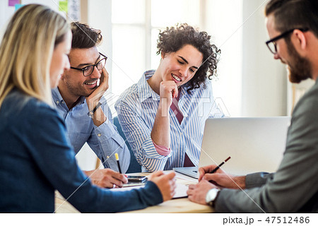 Group of young businesspeople with laptop working together in a modern office. 47512486