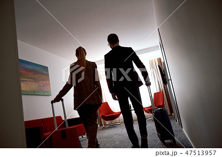 Two tired business people entering in a hotel room. Rear view 47513957