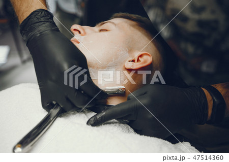 The man cuts his beard in the barbershop 47514360