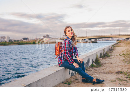 Smiling woman sitting on the riverbank Smiling woman sitting on the riverbank 47515580