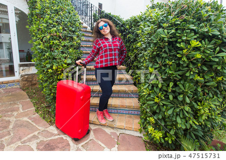 Holidays, travel, people concept - young woman in sunglasses standing on stairs with suitcases and Holidays, travel, people concept - young woman in sunglasses standing on stairs with suitcases and 47515731