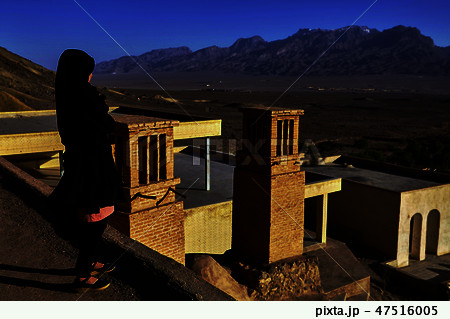 One girl in black chador looks at mountains, Yazd 47516005