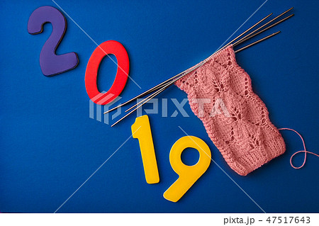 numbers 2019 and pink socks made of wool, knitted with an openwork pattern on four knitting needles 47517643
