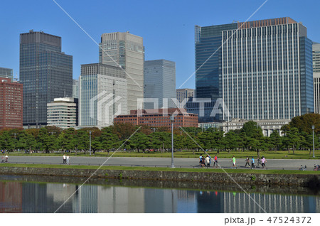 東京都千代田区の皇居（旧江戸城）の桜田門の内側近傍から皇居前広場と高層ビル街を撮影した写真 47524372
