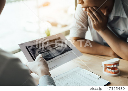Dentist hand pointing x-ray picture and talking Dentist hand pointing x-ray picture and talking 47525480