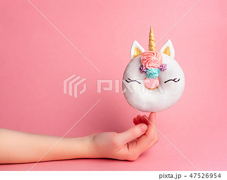 Unicorn donut on forefinger, copy space 47526954